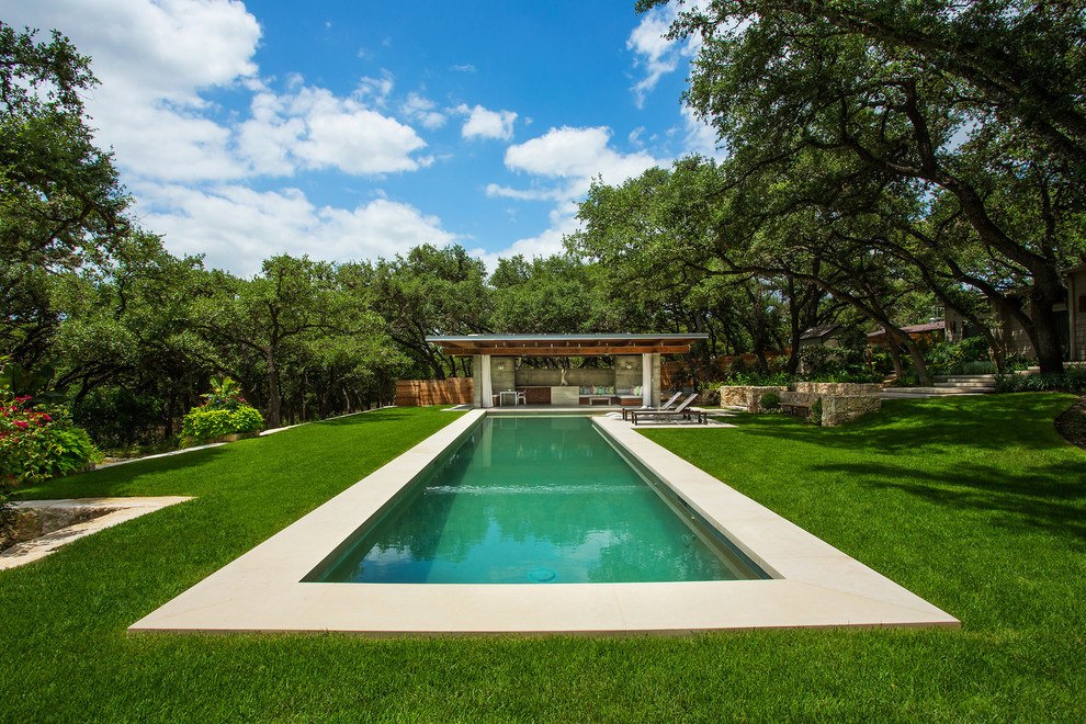 Diseño de casa de la piscina y piscina alargada moderna grande rectangular en patio trasero con adoquines de piedra natural