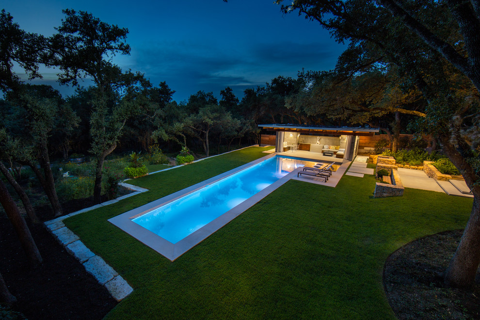 На фото: большой спортивный, прямоугольный бассейн на заднем дворе в стиле модернизм с домиком у бассейна и покрытием из каменной брусчатки с