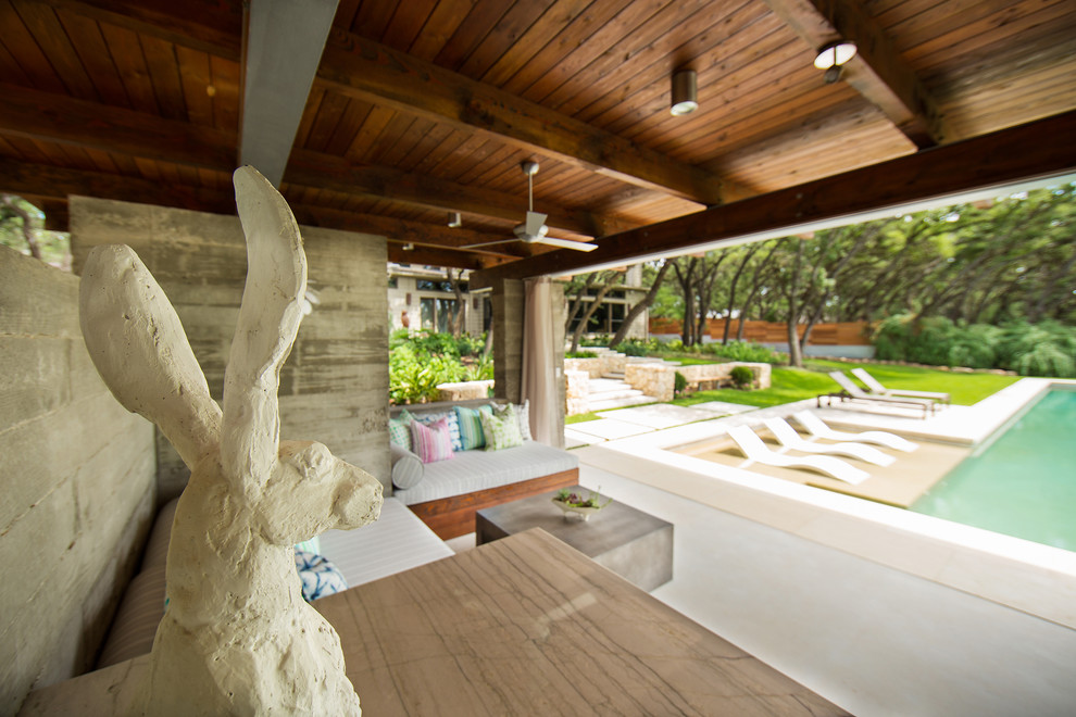 Idee per una grande piscina monocorsia moderna rettangolare dietro casa con una dépendance a bordo piscina e pavimentazioni in pietra naturale
