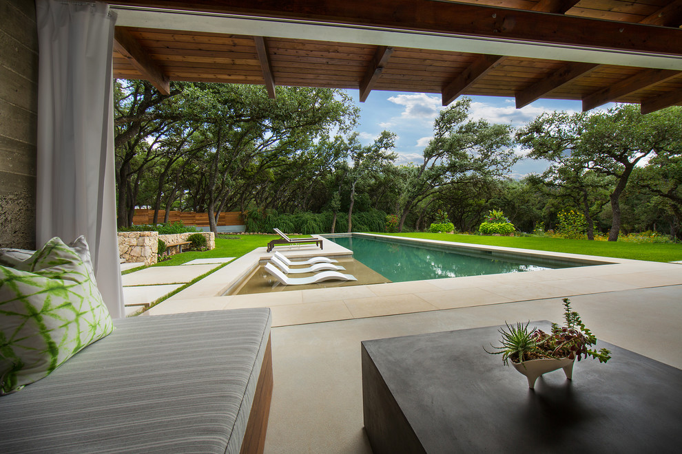 Idee per una grande piscina monocorsia minimalista rettangolare dietro casa con una dépendance a bordo piscina e pavimentazioni in pietra naturale