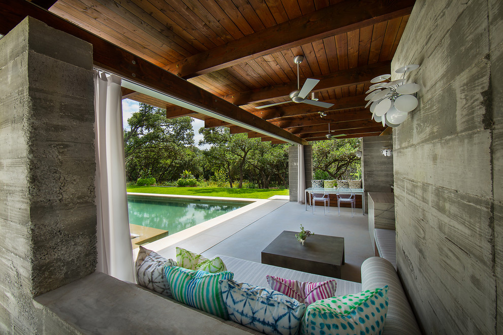 Modelo de casa de la piscina y piscina alargada minimalista grande rectangular en patio trasero con adoquines de piedra natural