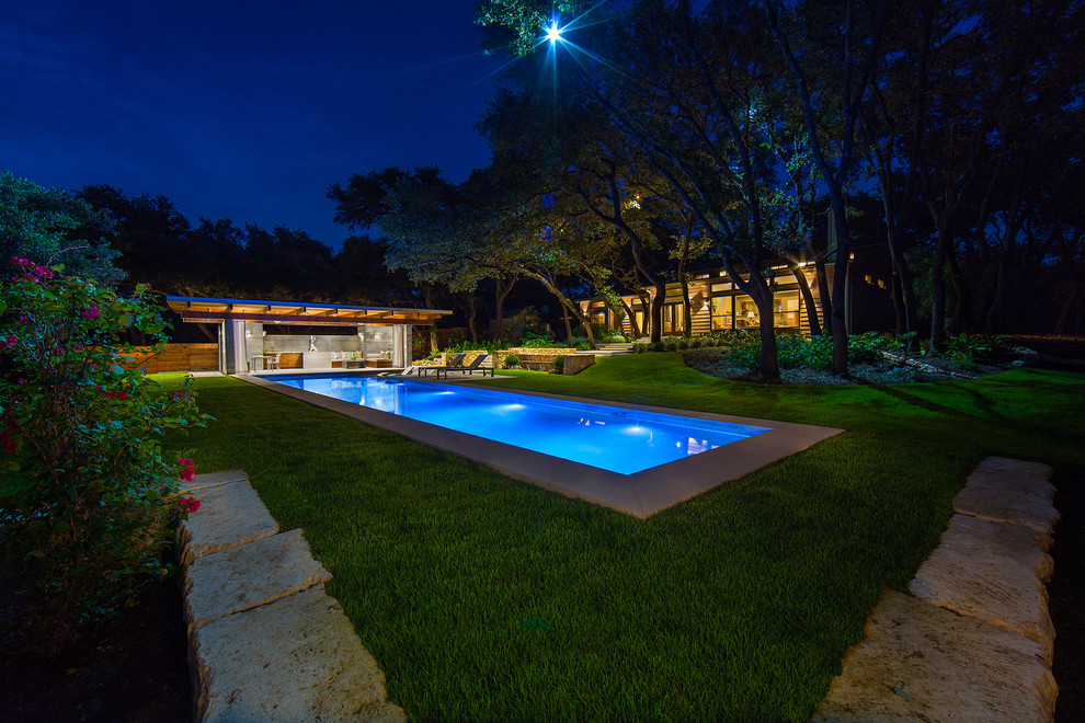 Inspiration pour une grande piscine arrière minimaliste rectangle avec des pavés en pierre naturelle.