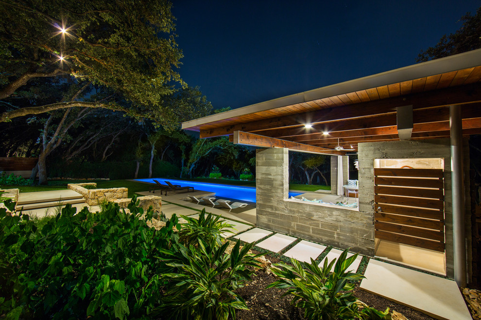 Large minimalist backyard stone and rectangular lap pool house photo in Austin