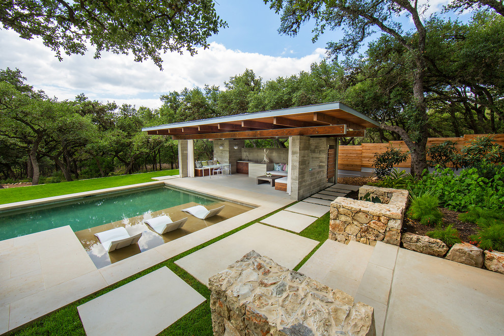 Идея дизайна: большой прямоугольный бассейн на заднем дворе в стиле модернизм с домиком у бассейна и покрытием из каменной брусчатки