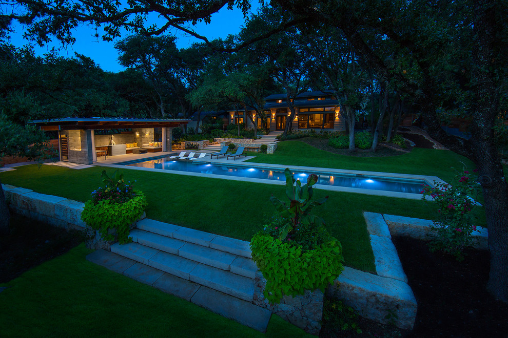 На фото: большой спортивный, прямоугольный бассейн на заднем дворе в стиле модернизм с домиком у бассейна и покрытием из каменной брусчатки