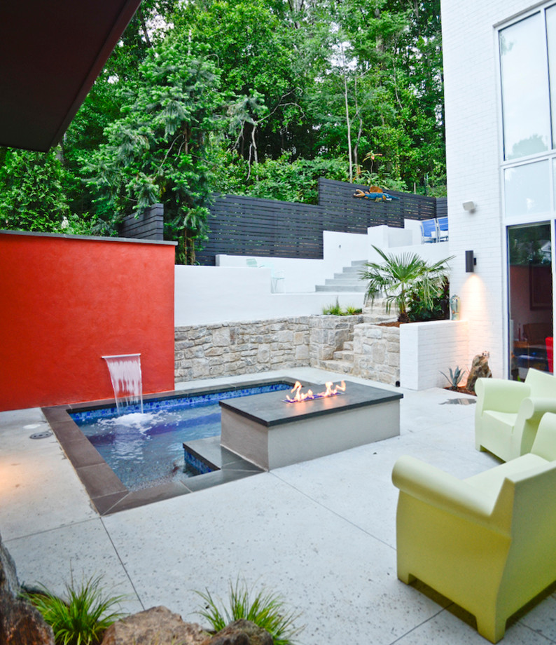 Imagen de piscina con fuente moderna pequeña rectangular en patio trasero con adoquines de piedra natural