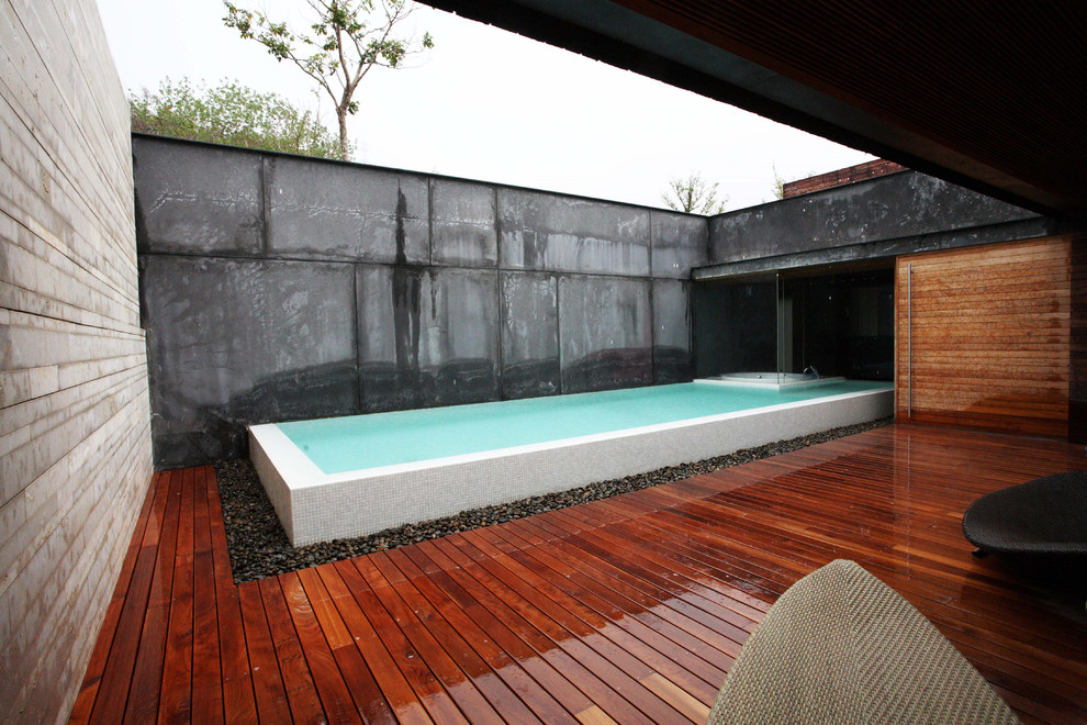 Inspiration for a mid-sized modern backyard rectangular aboveground hot tub remodel in Miami with decking