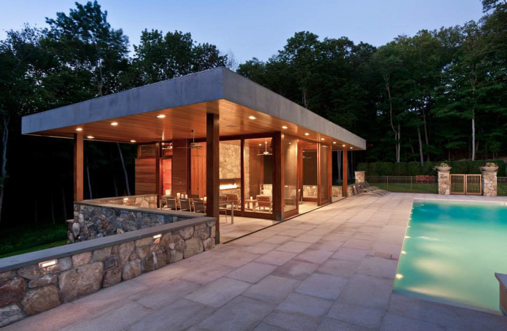 Design ideas for a medium sized modern back custom shaped swimming pool in New York with a pool house.