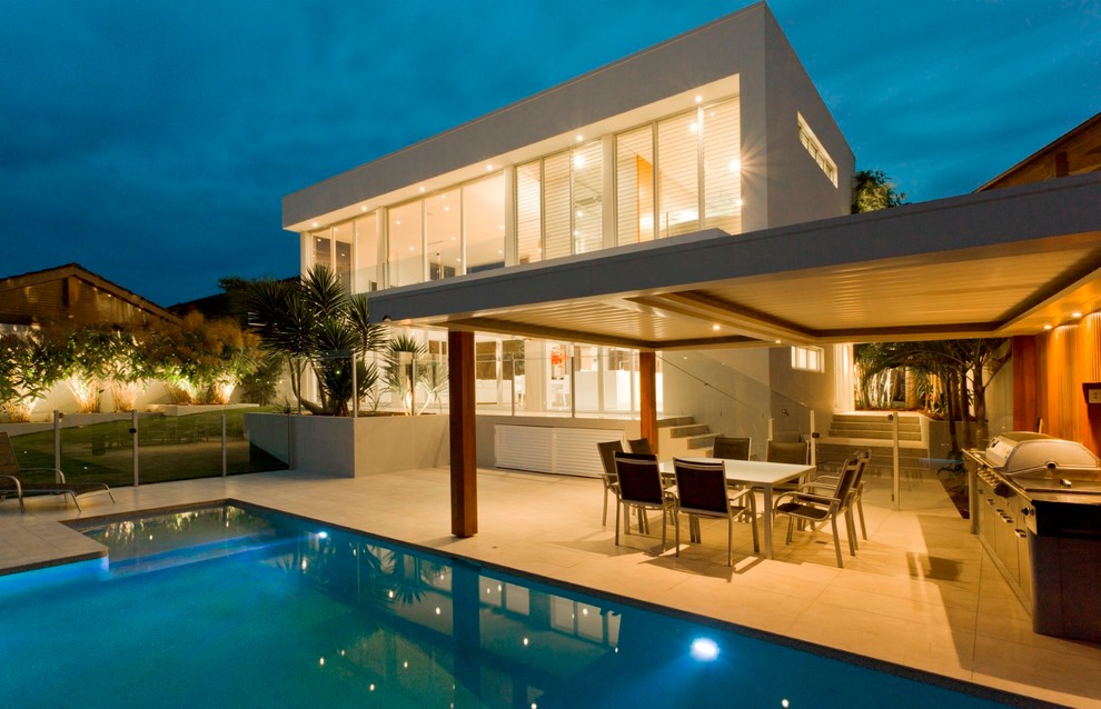 Inspiration for a modern back rectangular infinity swimming pool in Orange County with tiled flooring.