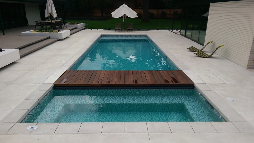 Ejemplo de piscinas y jacuzzis alargados minimalistas de tamaño medio rectangulares en patio trasero con suelo de hormigón estampado