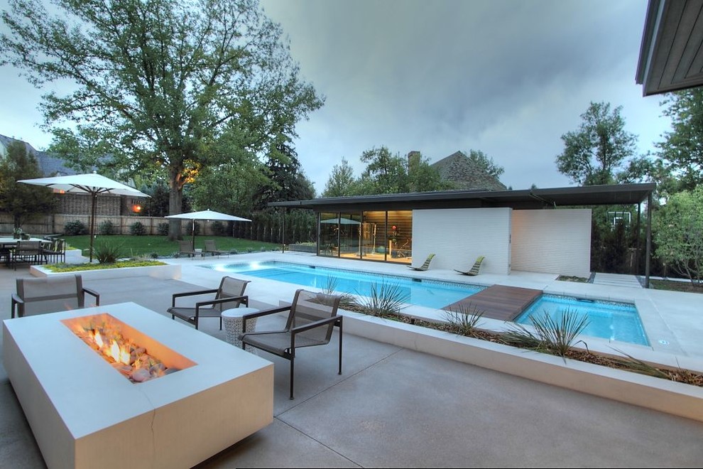 Inspiration for a mid-sized modern backyard stamped concrete and rectangular lap hot tub remodel in Denver