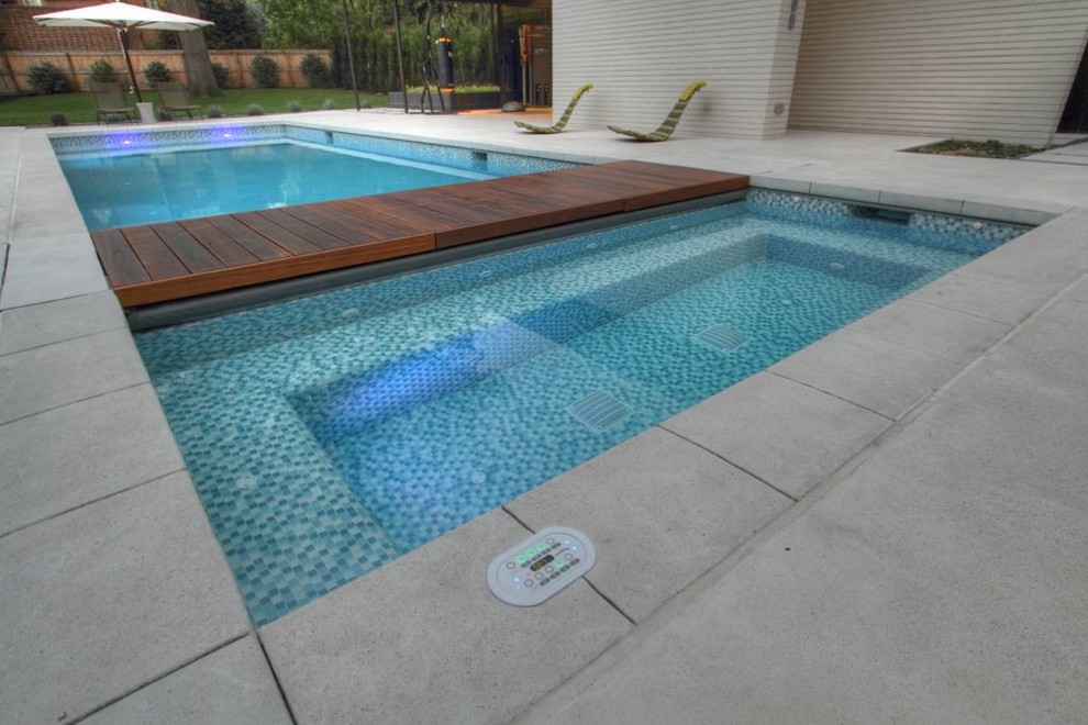 Ejemplo de piscinas y jacuzzis alargados modernos de tamaño medio rectangulares en patio trasero con suelo de hormigón estampado