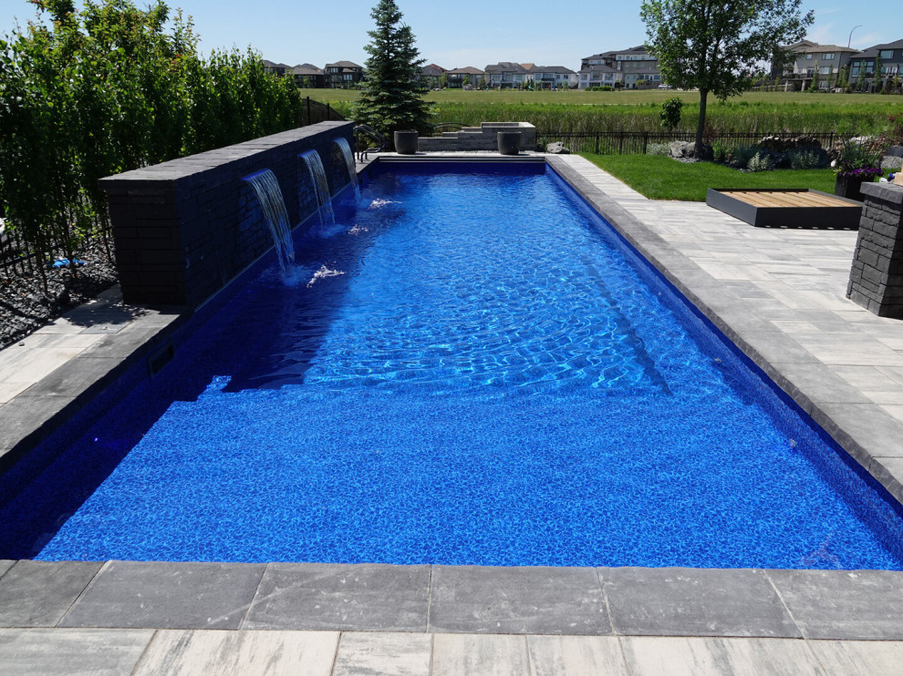 Foto di una piscina minimalista rettangolare di medie dimensioni e dietro casa con pavimentazioni in mattoni