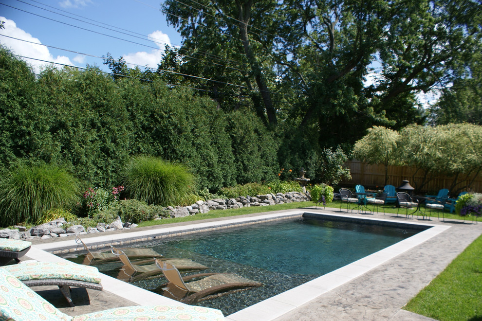 Idee per una piscina moderna rettangolare dietro casa con cemento stampato