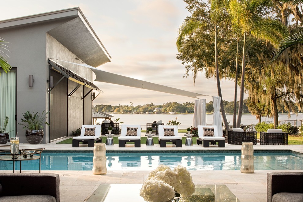 Foto de casa de la piscina y piscina alargada minimalista extra grande rectangular en patio trasero con adoquines de piedra natural