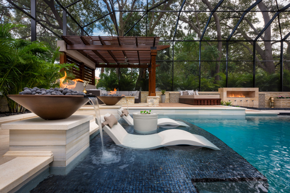 Diseño de piscina con fuente infinita grande a medida en patio trasero con adoquines de hormigón