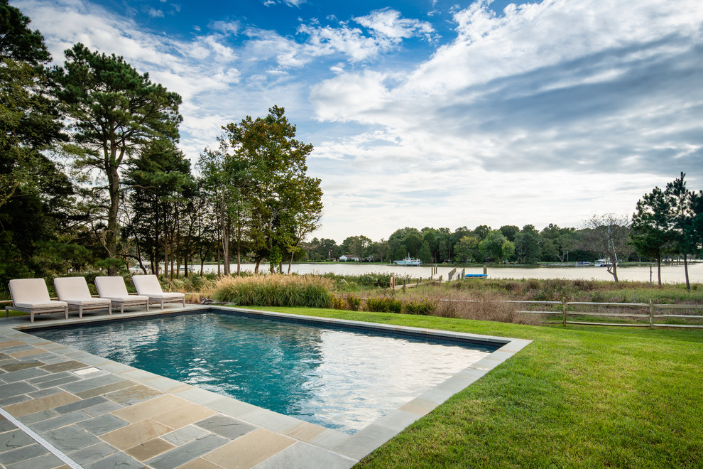 Esempio di un'ampia piscina naturale country rettangolare dietro casa con un acquascivolo e pavimentazioni in pietra naturale