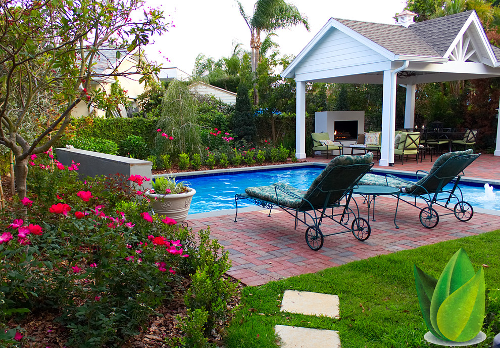 Mittelgroßer Klassischer Schwimmteich hinter dem Haus in individueller Form mit Wasserspiel und Pflastersteinen in Tampa