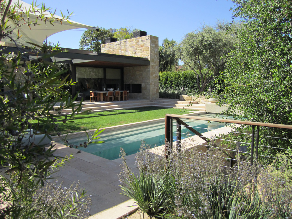 Стильный дизайн: спортивный, прямоугольный бассейн среднего размера на заднем дворе в стиле модернизм с покрытием из каменной брусчатки и джакузи - последний тренд