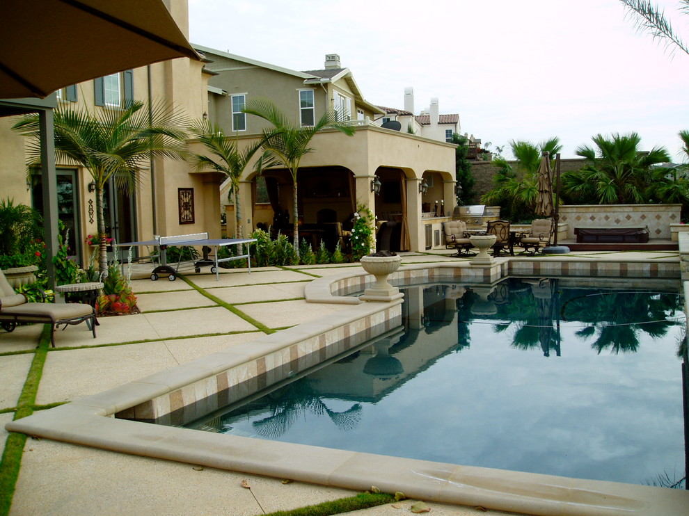 Ispirazione per una grande piscina naturale mediterranea personalizzata dietro casa con lastre di cemento