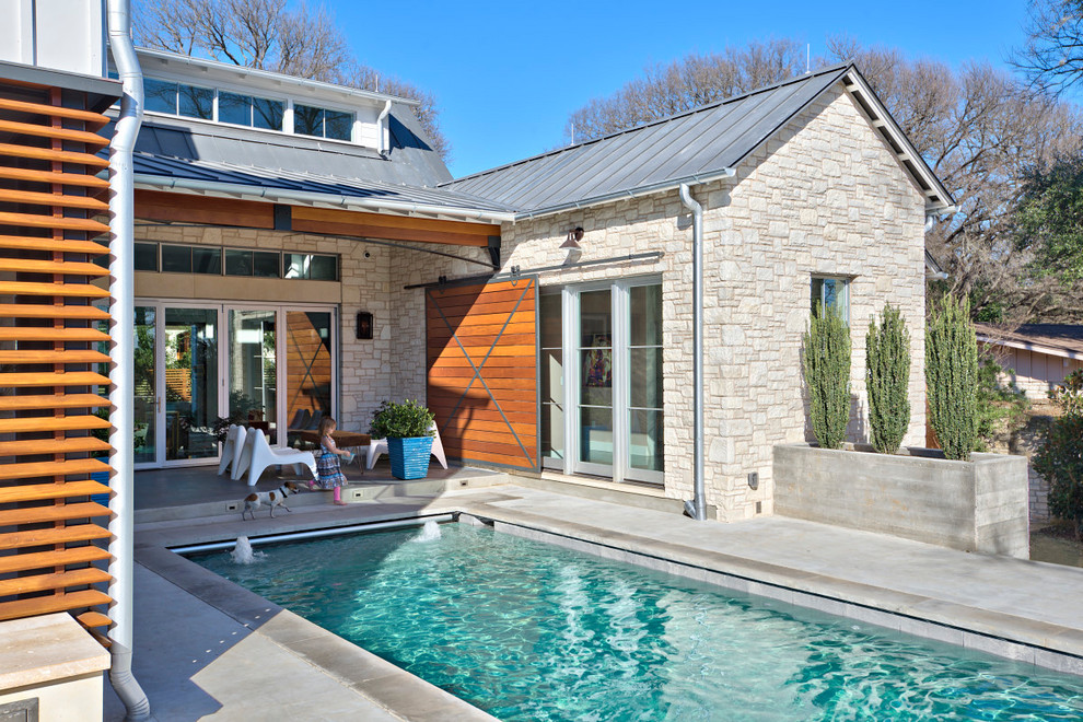 Imagen de piscina con fuente alargada campestre de tamaño medio rectangular en patio con losas de hormigón