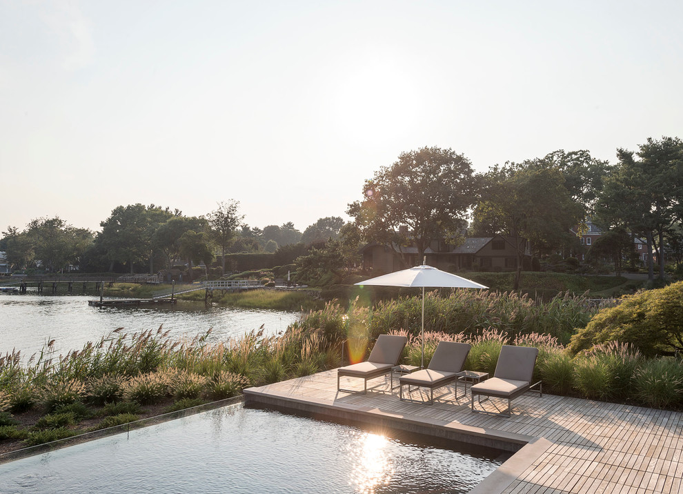 Cette image montre une piscine naturelle et arrière rustique de taille moyenne et sur mesure avec une terrasse en bois.
