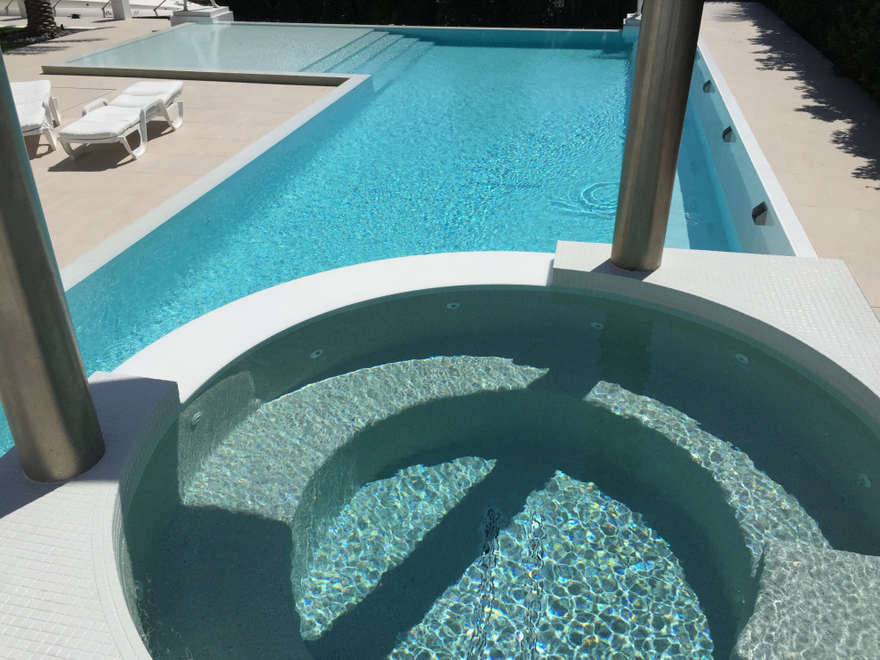 Diseño de piscina infinita minimalista rectangular con suelo de baldosas