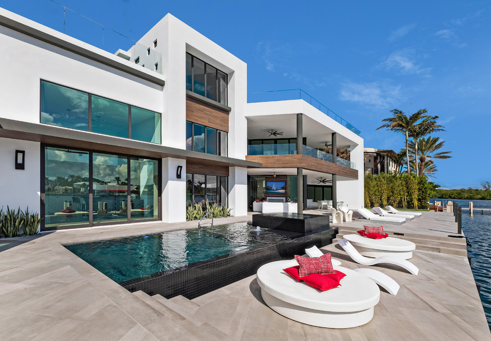 Hot tub - contemporary backyard tile and rectangular infinity hot tub idea in Miami