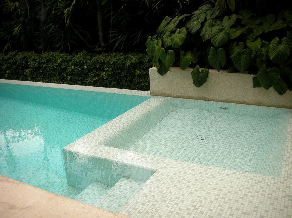Idee per una piscina fuori terra minimalista rettangolare di medie dimensioni e dietro casa con una vasca idromassaggio