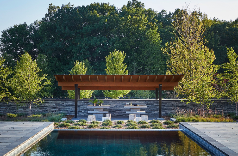 Pool - large modern backyard rectangular infinity pool idea in Milwaukee