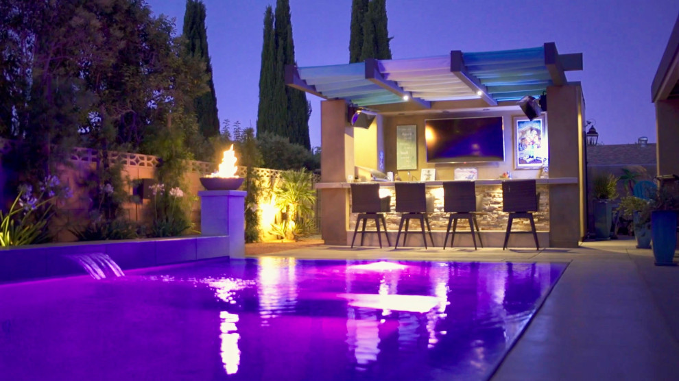 Foto di una piscina a sfioro infinito minimal rettangolare di medie dimensioni e dietro casa con lastre di cemento