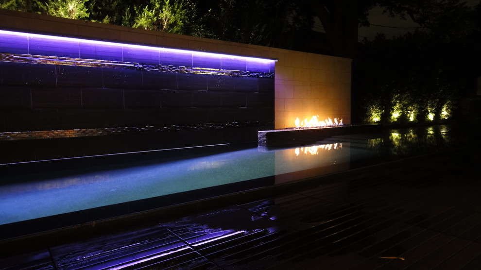 Aménagement d'une petite piscine à débordement et arrière moderne rectangle avec un point d'eau et une terrasse en bois.