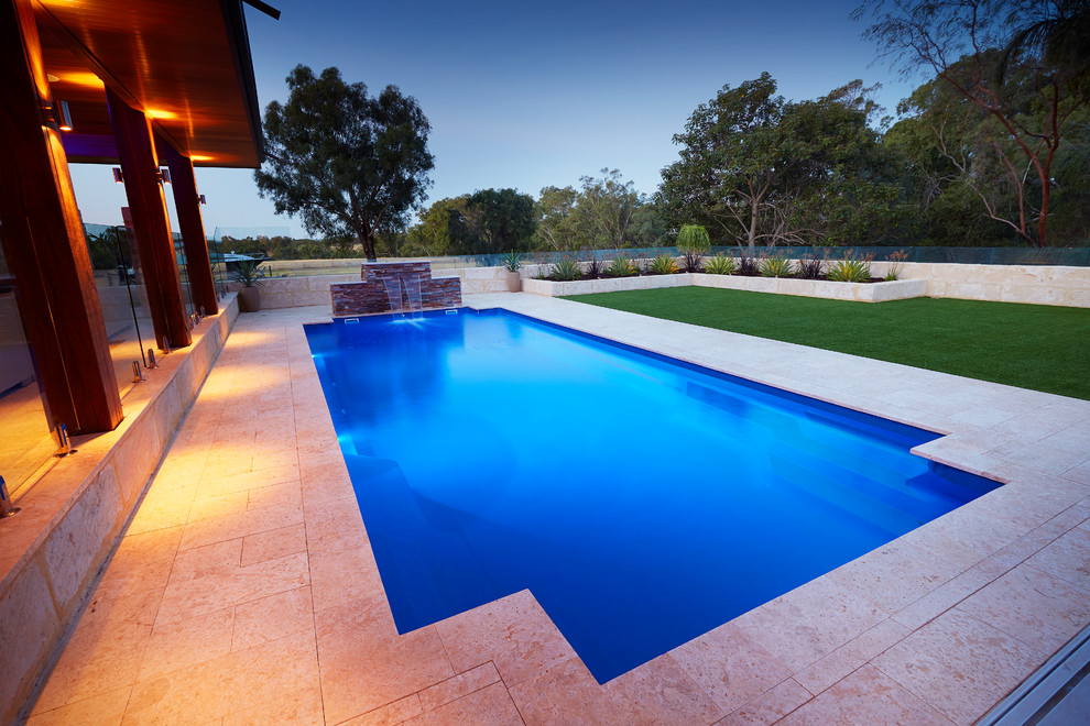 Immagine di una grande piscina moderna rettangolare dietro casa con fontane