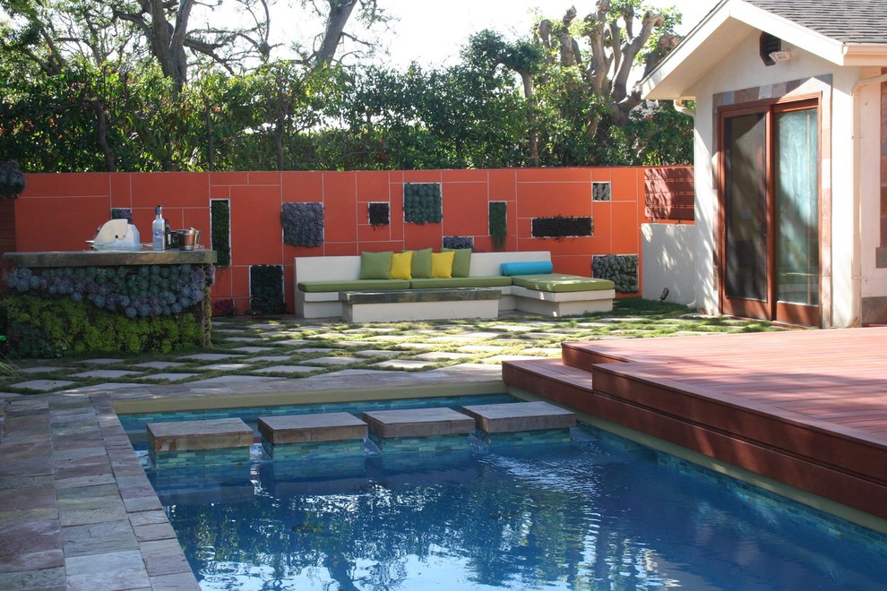 На фото: спортивный, прямоугольный бассейн среднего размера на заднем дворе в стиле модернизм с покрытием из каменной брусчатки