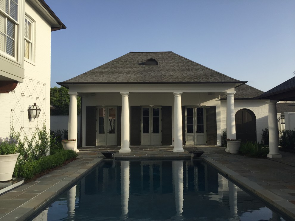 Medium sized bohemian back rectangular lengths swimming pool in New Orleans with a water feature and natural stone paving.