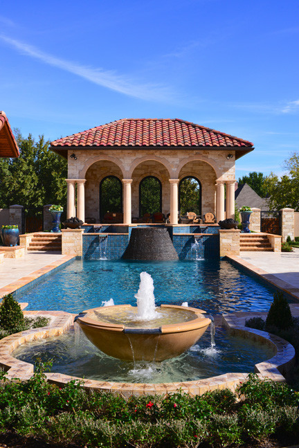 Esempio di una grande piscina vittoriana rettangolare dietro casa con fontane e piastrelle