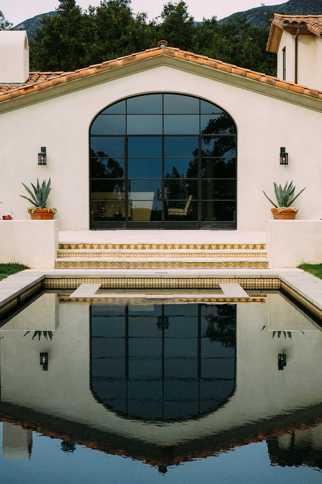 Foto di una grande piscina mediterranea rettangolare in cortile con lastre di cemento