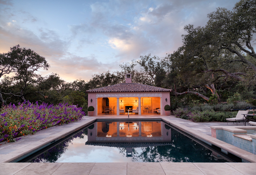 Imagen de casa de la piscina y piscina mediterránea rectangular en patio trasero con adoquines de piedra natural