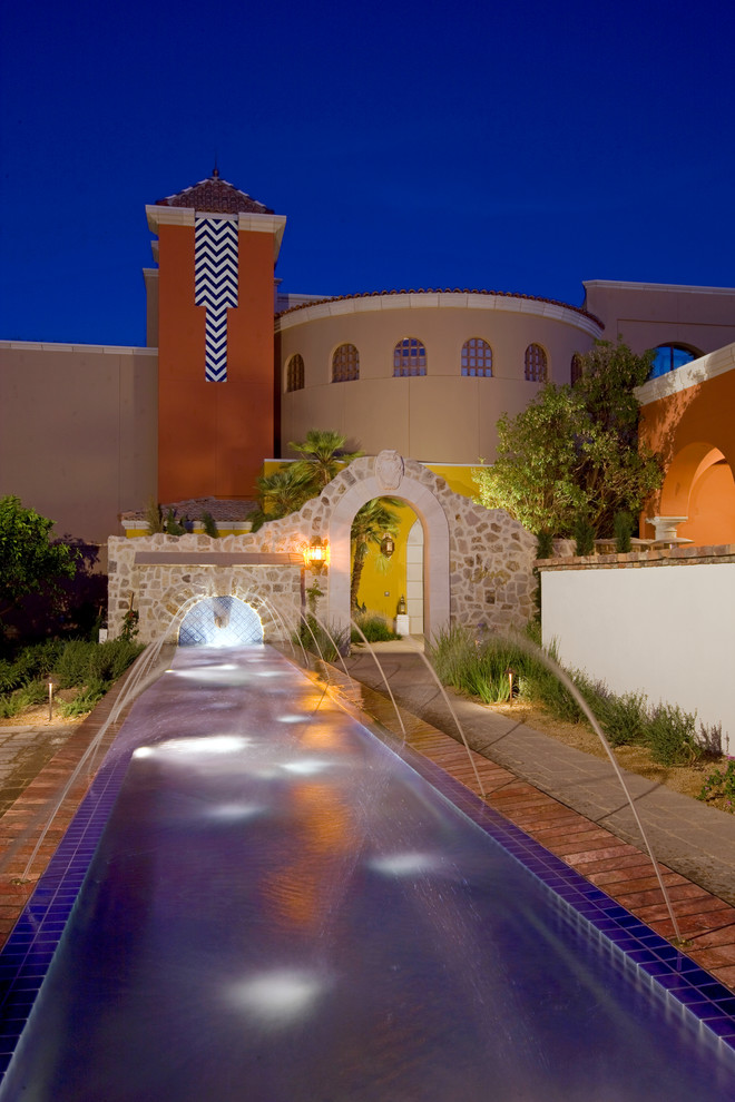フェニックスにある広い地中海スタイルのおしゃれなプール (噴水、コンクリート敷き	) の写真