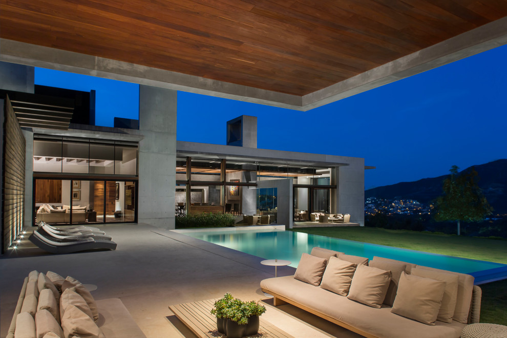 Moderner Infinity-Pool hinter dem Haus in rechteckiger Form mit Betonplatten in Sonstige