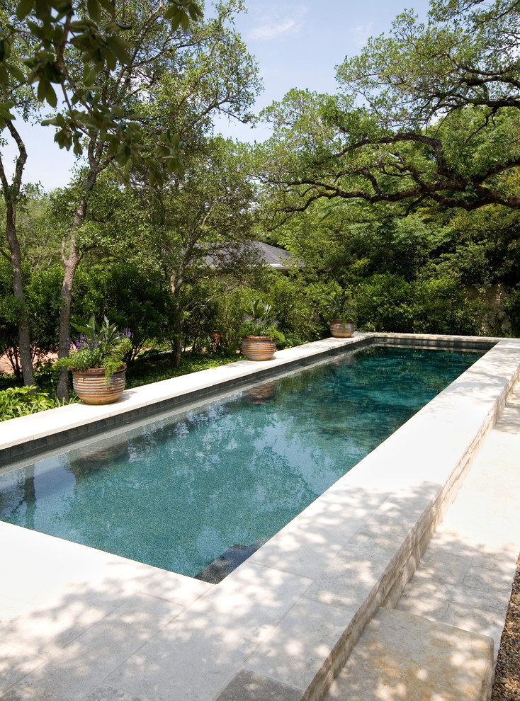 Пример оригинального дизайна: большой прямоугольный, спортивный бассейн на заднем дворе в классическом стиле
