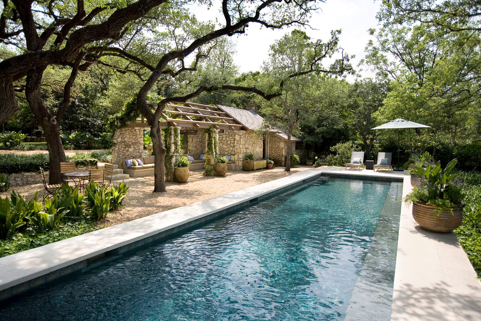 На фото: большой прямоугольный, спортивный бассейн на заднем дворе в классическом стиле с домиком у бассейна и покрытием из каменной брусчатки с