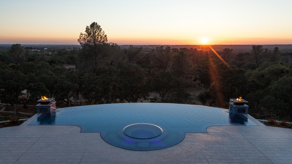 Стильный дизайн: бассейн-инфинити произвольной формы на заднем дворе в средиземноморском стиле с покрытием из плитки - последний тренд