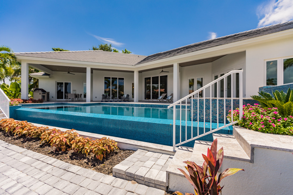 Mittelgroßer Klassischer Pool hinter dem Haus in rechteckiger Form mit Natursteinplatten in Miami