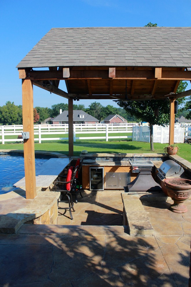 Foto di una grande piscina monocorsia stile rurale personalizzata dietro casa con cemento stampato e una dépendance a bordo piscina