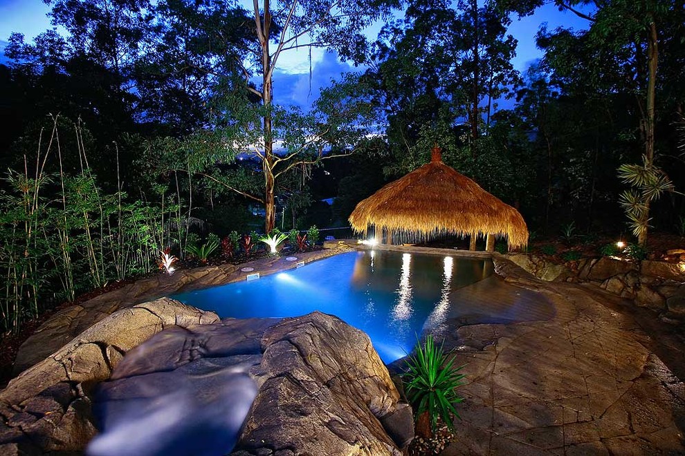 Cette photo montre une piscine naturelle et avant exotique de taille moyenne et sur mesure avec un toboggan et du béton estampé.