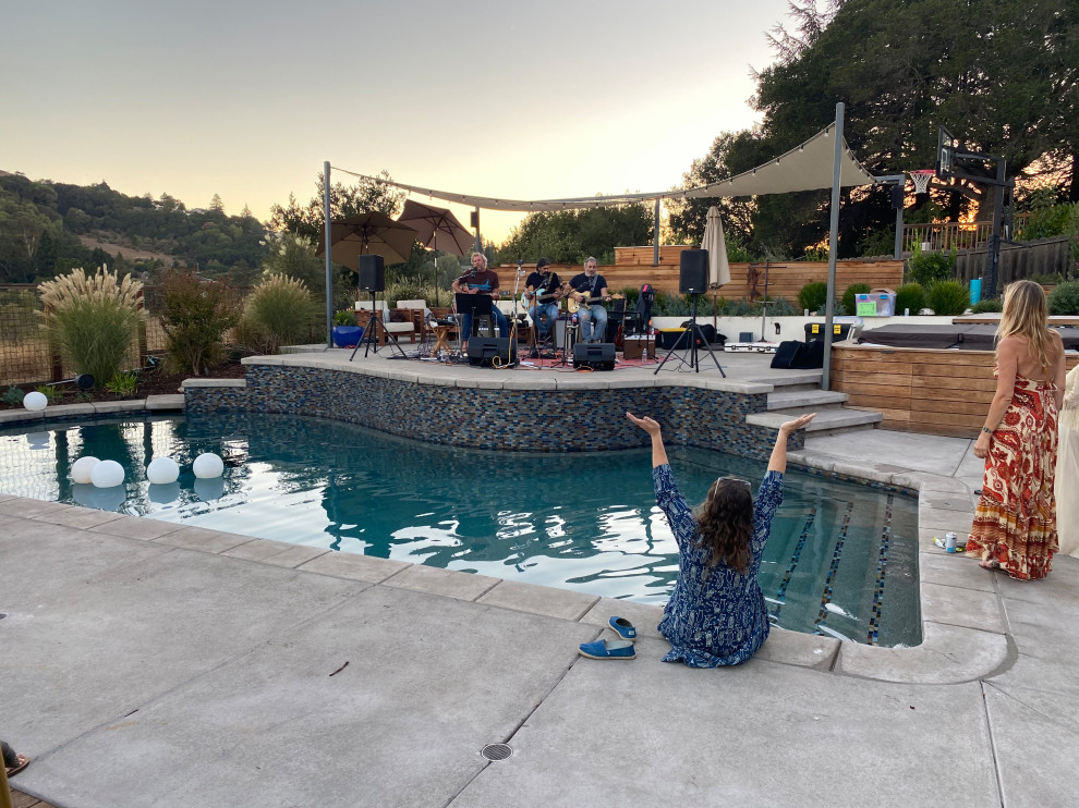 Immagine di una grande piscina naturale minimalista personalizzata dietro casa con paesaggistica bordo piscina e lastre di cemento