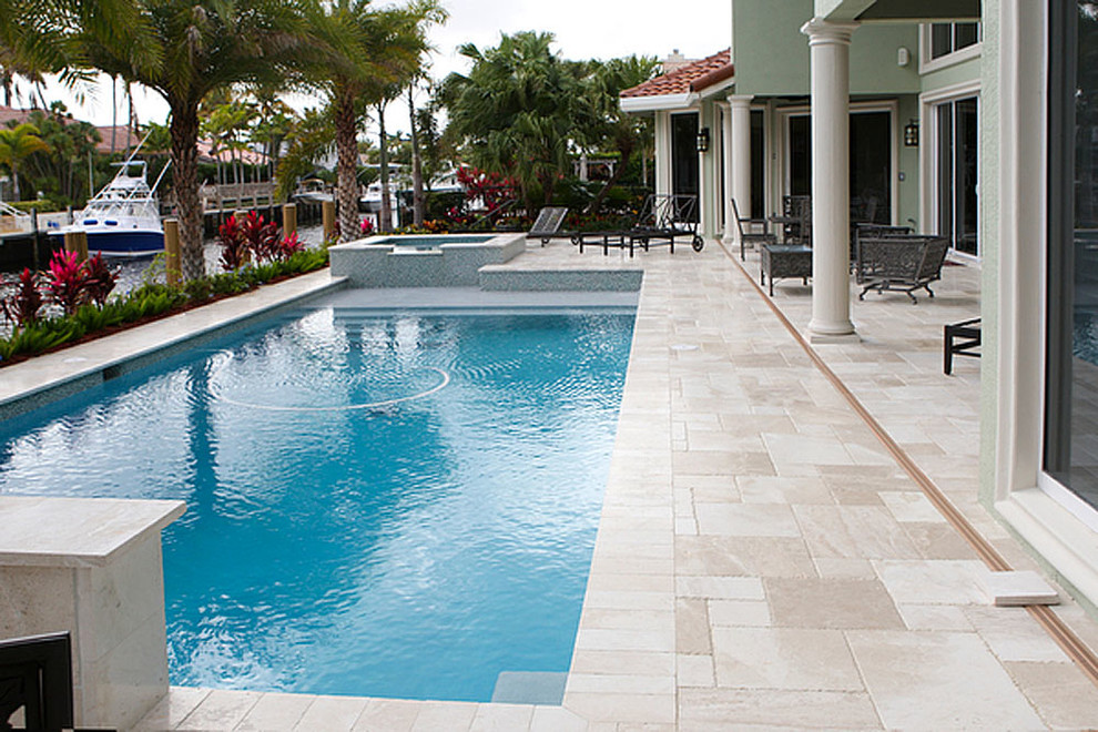 Diseño de piscinas y jacuzzis alargados costeros grandes rectangulares en patio trasero con suelo de baldosas