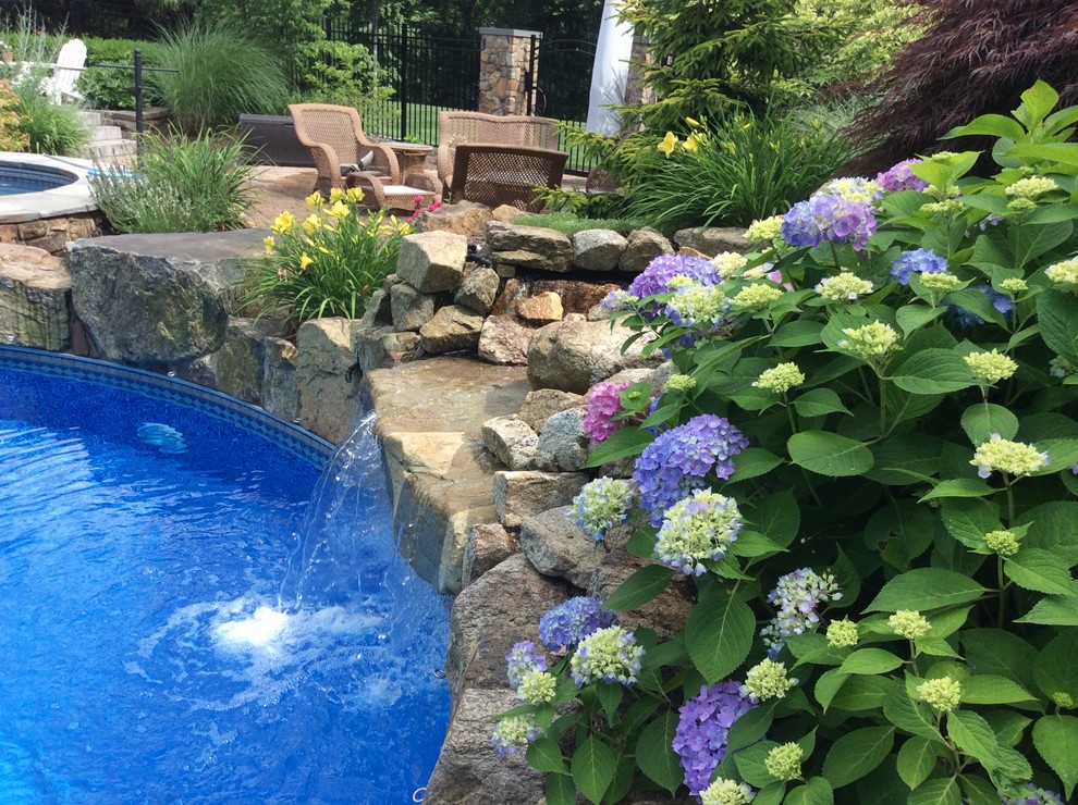 Inspiration for a large timeless backyard concrete paver and custom-shaped natural pool fountain remodel in New York