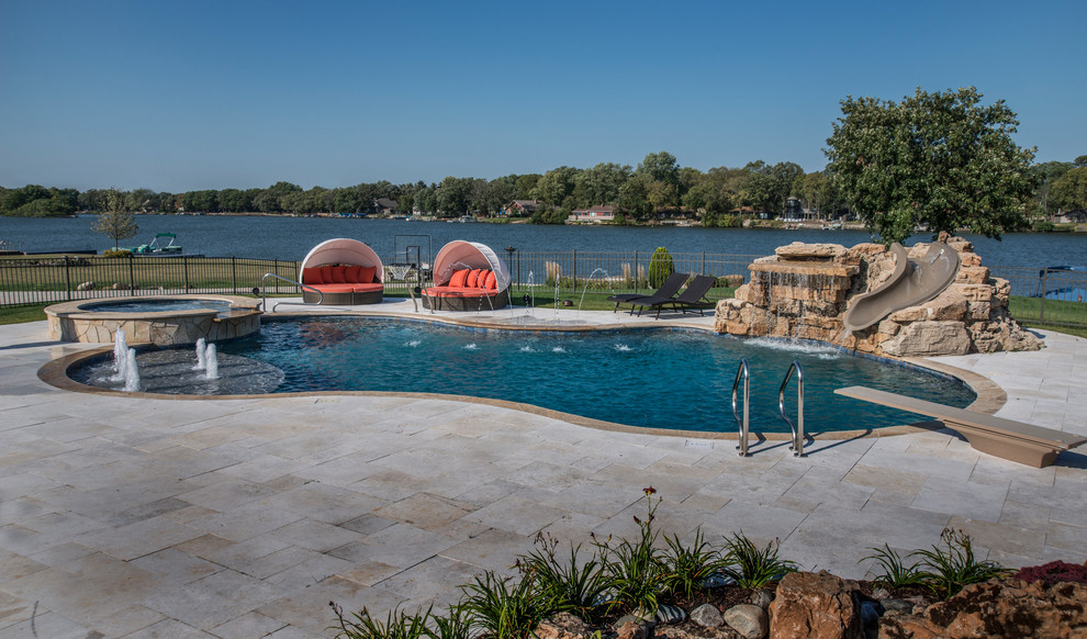 Esempio di una piscina naturale tradizionale personalizzata di medie dimensioni e dietro casa con una vasca idromassaggio e pavimentazioni in pietra naturale